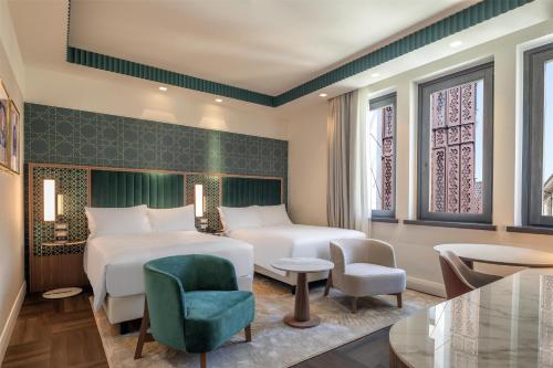 a hotel room with a bed and a chair at Hilton Turin Centre in Turin