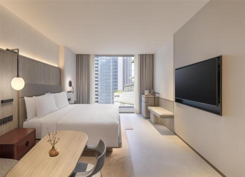 a hotel room with a bed and a tv at Kromo Bangkok, Curio Collection By Hilton in Bangkok