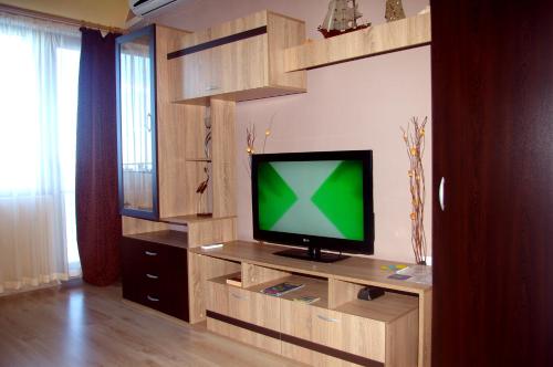 uma sala de estar com televisão num centro de entretenimento em madeira em Sea View Apartments em Sozopol