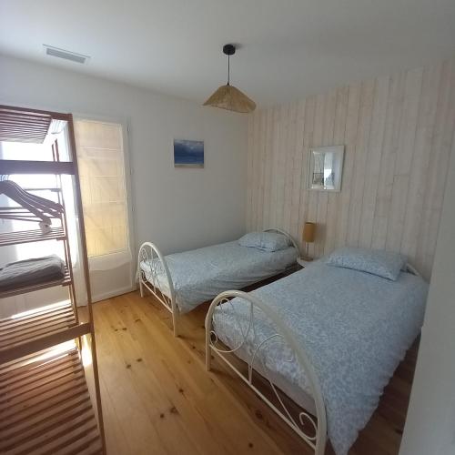 une chambre avec deux lits et une fenêtre dans l'établissement CASSY Maison 3 chambres avec jardin, à Lanton