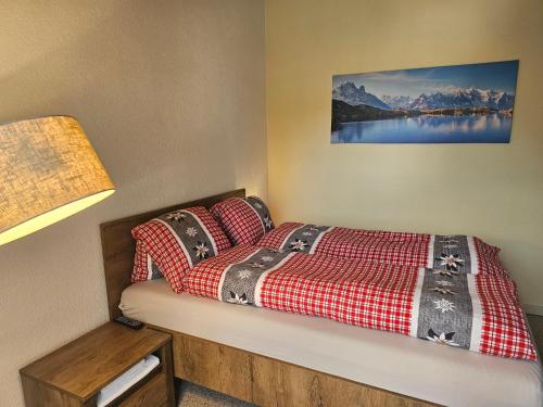 a bedroom with a bed with a red and white blanket at Lake Lodge in Därligen
