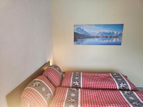 a bedroom with a bed and a picture of mountains at Lake Lodge in Därligen