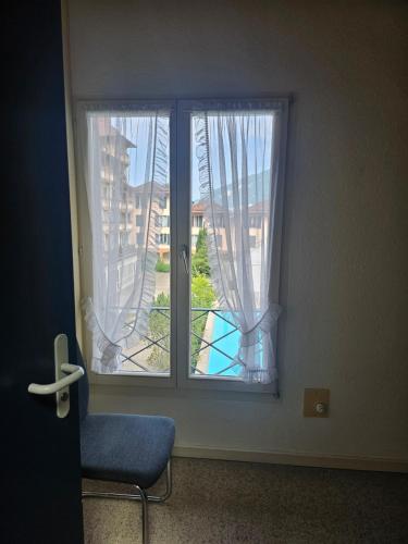 a window with a blue chair in front of it at Lake Lodge in Därligen