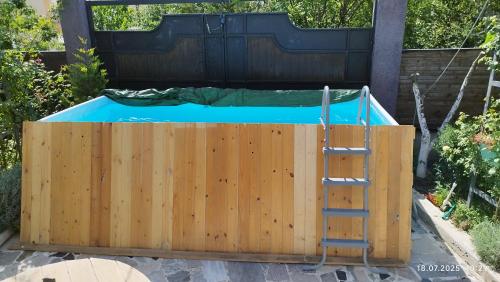 a pool with a wooden fence and a ladder at dream villa in Tbilisi City