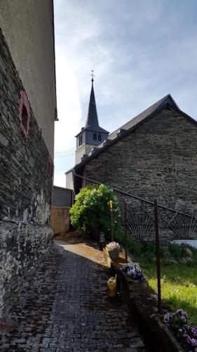 a building with a church with a steeple in the background at Zur Dorfschänke in Hausen