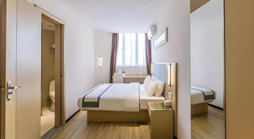 a hotel room with a bed and a window at City Comfort Inn Dangtu High Speed East Railway Station RT-Mart in Ma'anshan