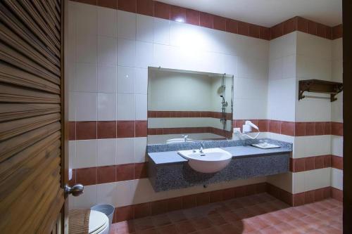 a bathroom with a sink and a mirror at Phuphaya Resort Pattaya in Pattaya South