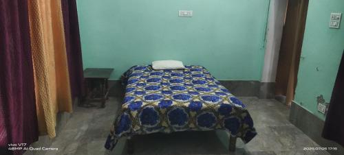 a bed with a quilt on it in a room at Sharma Homestay in Kālīnagar