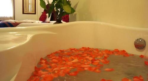 a white bath tub filled with lots of orange carrots at The View Pavilion Hotel in Luang Prabang