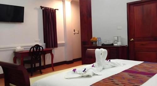 a hotel room with a bed with white shoes on it at The View Pavilion Hotel in Luang Prabang