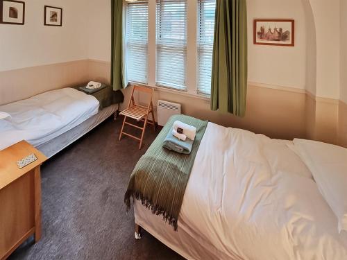 a bedroom with two beds and a desk and a chair at Bird's Eye View in Dornoch
