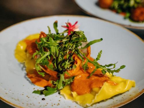 un piatto bianco con un piatto di cibo su un tavolo di Hai Tide Beach Resort a Nusa Lembongan