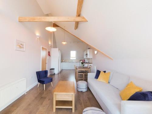 a living room with a couch and a table at Sea Is All Around in Mundesley