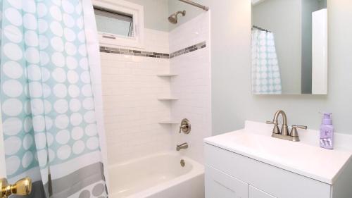 un bagno bianco con lavandino e doccia di Cliffside Cottage a North Cape May