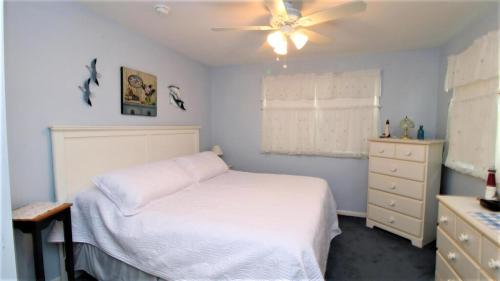una camera da letto con un letto e un ventilatore a soffitto di Cliffside Cottage a North Cape May