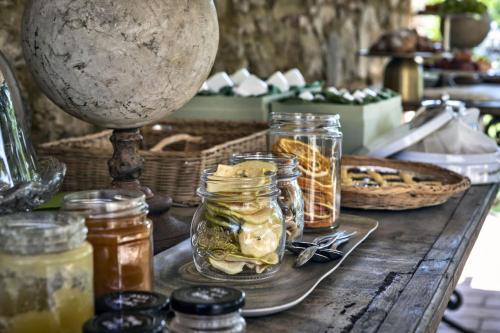 a table with jars of pickles and a wine glass at Villa Pieve San Giovanni in Lustignano