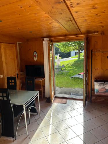 Studio vallée de Chamonix في لي أوش: غرفة طعام بها طاولة وباب زجاجي منزلق