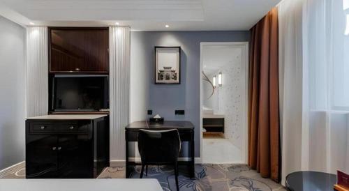 a room with a desk and a table in a room at Jinjiang Metropolo Hotel Nanjing Confucius Temple Branch in Nanjing