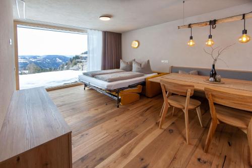 a living room with a bed and a table and a dining room at Biohof Oberwerkstatt HAIDI in Obereggen