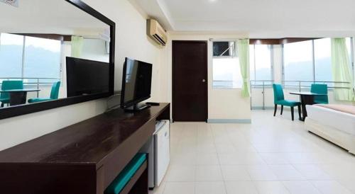 a living room with a television and a couch at Nice Beach Hotel in Rayong