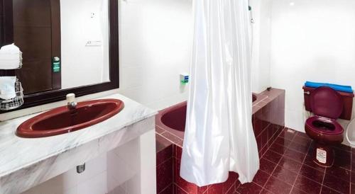 a bathroom with a red sink and a toilet at Nice Beach Hotel in Rayong