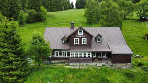 a large wooden house in a green field at Chata Šohajka - all inclusive & wellness in Pec pod Sněžkou
