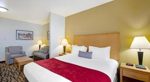 a hotel room with a large bed and a chair at Best Western Plus Guymon Hotel and Suites in Guymon