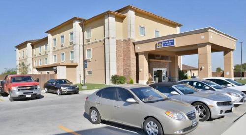 a parking lot with cars parked in front of a building at Best Western Plus Guymon Hotel and Suites in Guymon