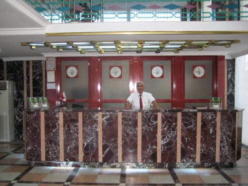 a man standing behind a bar in a restaurant at Miroglu Hotel in Diyarbakır