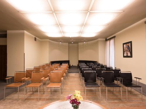 a room with rows of chairs and flowers in it at Tufenkian Avan Dzoraget Hotel in Dzoraget