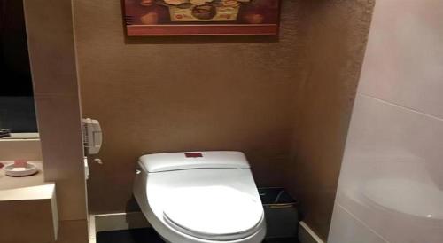 a bathroom with a toilet and a picture on the wall at Dunhuang Grand Soluxe Hotel in Dunhuang