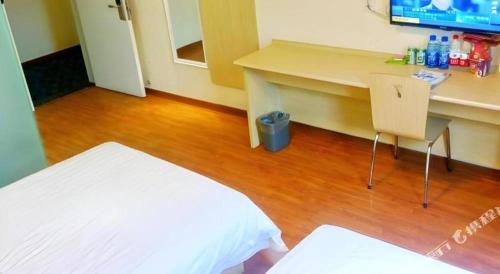 a bedroom with a desk and a bed and a table at 7 Days Inn Xi'an Railway Station in Xi'an