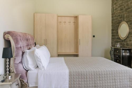 a bedroom with a white bed and a chair at LOTOS Families Αpartments 1 in Konitsa