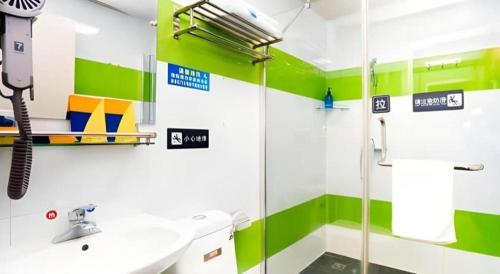 a green and white bathroom with a sink and a shower at 7 Days Inn Xi'an Railway Station in Xi'an