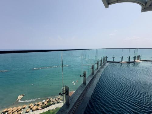 a swimming pool with a view of the ocean at Luxury 1 Bed in Trilogy, Limassol Seafront in Limassol