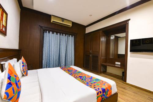 Un dormitorio con una cama y un televisor. en FabHotel Siris 18 - Aravali Biodiversity Park, en Gurgaon