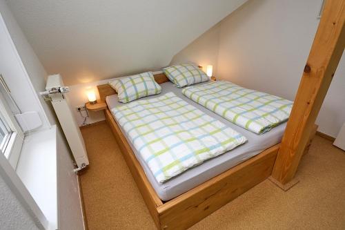 a small bedroom with a bed with two pillows at Ferienwohnung Haxloh 7 in Fintel