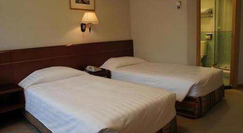 two beds in a hotel room with at West Hotel in Hong Kong