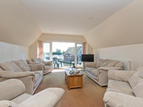a large living room with couches and a tv at Puddle Inn Duck in Horning