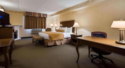 a hotel room with a bed and a desk at Best Western Plus Orillia Hotel in Orillia