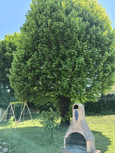a stone structure in front of a tree at Gîte climatisé à 15 min de Lyon avec jardin privé in Feyzin