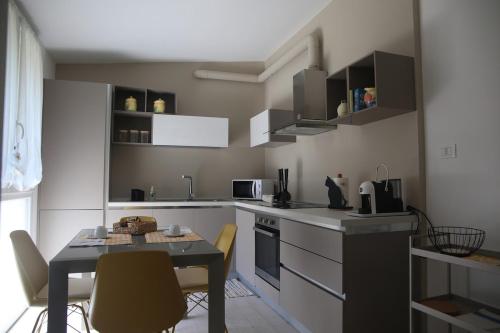 a small kitchen with a table and a table and chairs at A Casa di Lilly in Albenga