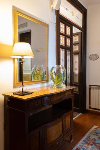 a table with a mirror and two vases on it at Hotel Ambasciatori in Palermo
