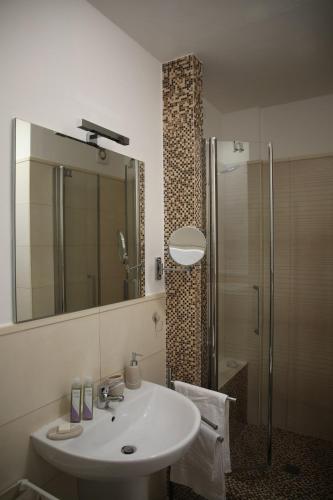 a bathroom with a sink and a shower with a mirror at A Casa di Lilly in Albenga