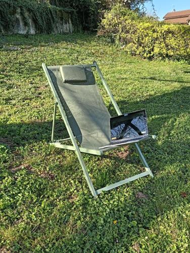 a folding chair sitting on the grass in a field at Gîte climatisé à 15 min de Lyon avec jardin privé in Feyzin