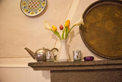 a vase with flowers on a table next to a mirror at Albergo Ristorante La Rocca in Firenzuola