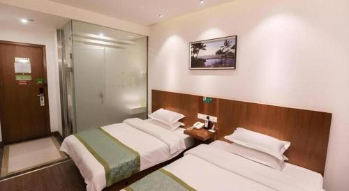 a hotel room with two beds and a phone at Vatica Shanghai Jiading District Anting Metro Station Moyu Road Hotel in Shanghai