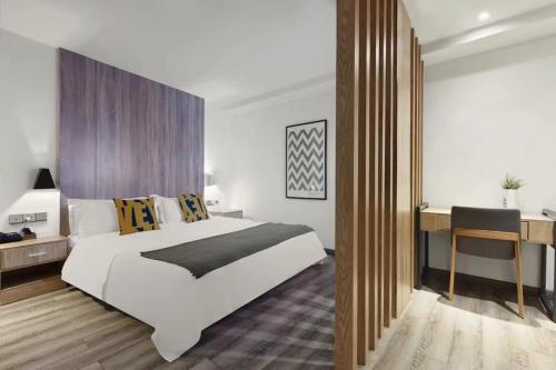 a bedroom with a large white bed and a desk at Bi'an Time Hotel -Chongqing Guanyin Bridge Branch in Chongqing