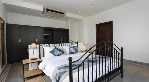 a bedroom with a large bed with blue and white pillows at Boutique Kampot Hotel in Kampot