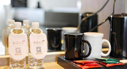 two bottles of wine sitting on a counter with a coffee pot at Jinjiang Metropolo Shanghai Xujiahui Nanhuating Hotel in Shanghai